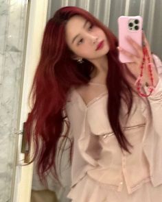 a woman with red hair taking a selfie in the mirror while wearing a white dress