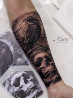 a man's arm with a skull and raven tattoo on the left side of his arm