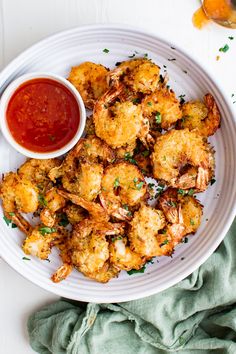 a white plate topped with fried shrimp next to a small bowl of ketchup