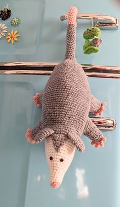 a knitted animal hanging from the side of a refrigerator door with magnets attached to it