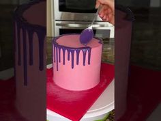 a pink and purple cake sitting on top of a table