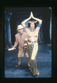 a man standing next to a woman in costume