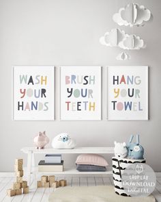 three posters are hanging on the wall above a white table with toys in front of it