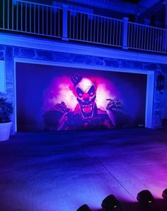 an image of a clown painted on the side of a garage door at night time