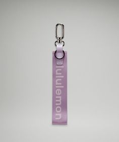 a purple keychain with the word millennium on it and a metal hook attached to it