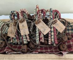 several christmas candy canes wrapped in twine and tied with brown paper tags, on top of a plaid blanket