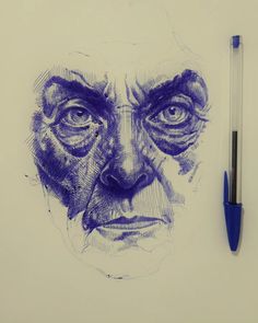 a drawing of an old man's face with eyes drawn on paper next to a pen