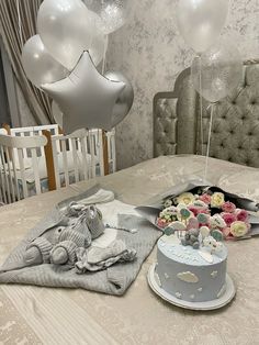 a cake and cupcakes on a table with balloons in the air above it