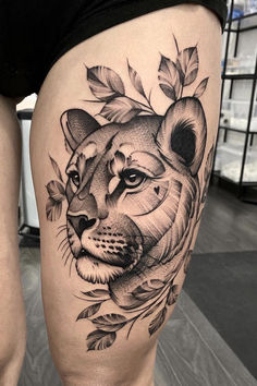 a woman's thigh with a tattoo of a tiger and leaves on the side