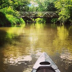 a canoe is going down the river under a bridge