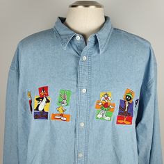 Nwot Vintage Warner Bros. Looney Tunes Button Down Denim Shirt Size Xxl Super Cool Shirt From The 90's With The Looney Tune Characters Embroidered On The Front. Nwot, Please Review All Photos (Cleaned). 100% Cotton Approximate Measurements Chest 52 In, Waist 51 In, Hips 48 In, Sleeve Length 25 In, Shoulder To Shoulder 23 1/2 In, Length 31 In Bundle 2 Or More Items And Receive 20% Off And Discounted Shipping! Thanks For Looking. Box11 Light Wash Button-up Top For Streetwear, Long Sleeve Denim Top With Graphic Print, Retro Button-up Denim Top, Retro Denim Button-up Top, Retro Long Sleeve Denim Top, 90s Blue Button-up Top, Jean Button Up Shirt, Button Collar Shirt, Denim Shirt Men