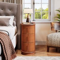 a bedroom scene with focus on the bed and nightstand, along with a chair that has a footstool