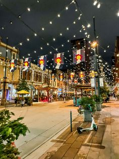 an empty city street at night with lights strung overhead