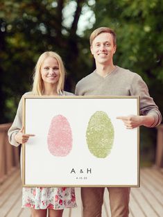 a man and woman holding up a sign with finger prints on it