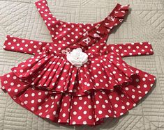 a red and white polka dot dress on a bed