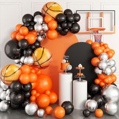 an orange and black balloon arch with basketballs on the hoop in front of it