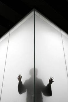 the shadow of a person behind a glass wall