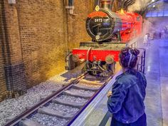 a woman looking at a train on display in a museum