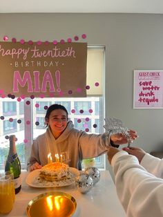 a woman sitting at a table with a birthday cake