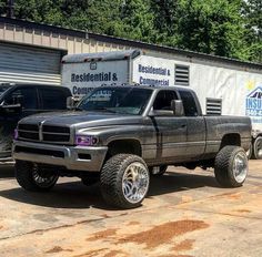 a truck is parked in front of a storage building with two trucks behind it and an industrial & commercial company logo on the side