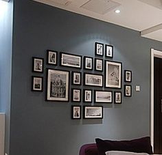 a living room filled with furniture and framed pictures on the wall above it's doorway