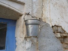 a metal bucket hanging from the side of a building