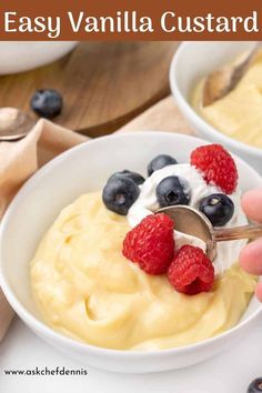 a bowl of yogurt with berries and blueberries in it is being spooned