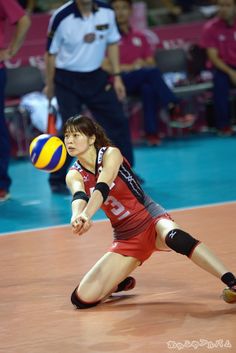 a female volleyball player is reaching for the ball during a game with other players in the background