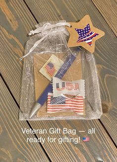 an american flag gift bag is on the floor next to a pen and star ornament