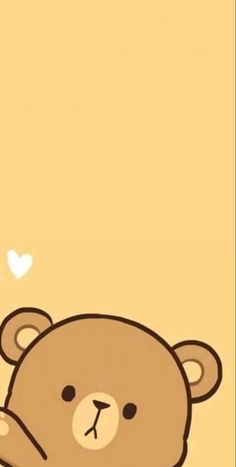 a brown teddy bear sitting on top of a wooden floor next to a heart shaped balloon