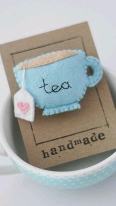 a tea bag in a cup with the word handmade on it and a tag attached to it