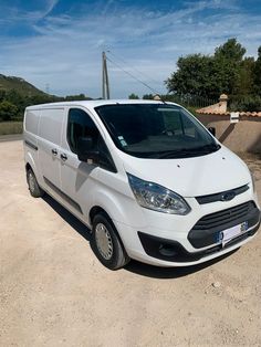 a white van is parked in the dirt