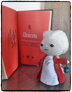 a crocheted stuffed animal next to an open book