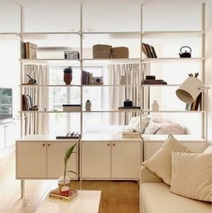 a living room filled with furniture and bookshelves next to a white couch in front of a window