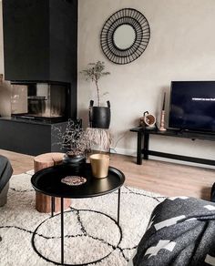 a living room filled with furniture and a flat screen tv on top of a wooden table