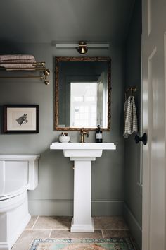 a white sink sitting under a mirror in a bathroom