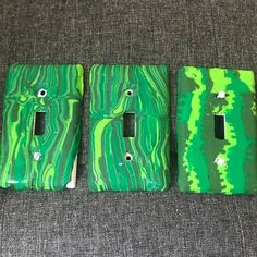 three green and white switch plates sitting on top of a couch