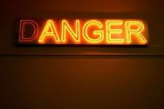 a neon sign that says danger on the wall