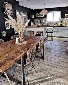 a wooden table sitting in the middle of a kitchen next to chairs and counter tops