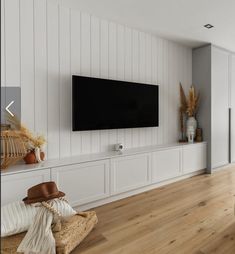 a living room filled with furniture and a flat screen tv mounted on the wall above it