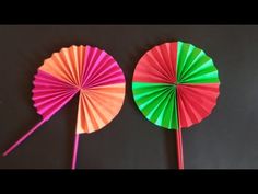 two colorful paper fans sitting next to each other