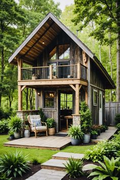 a small wooden cabin in the middle of some trees and grass with stairs leading up to it