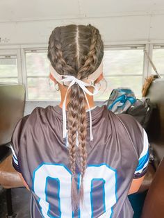 a girl with braids in her hair wearing a football jersey