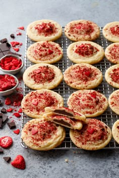 cookies with red sprinkles and chocolate chips on a cooling rack next to them