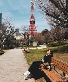 a woman sitting on a bench in front of the eiffel tower