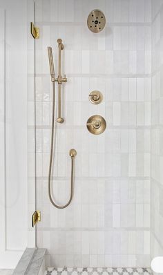 a bathroom with a shower head and hand held shower faucet in the corner