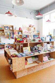 the children's book store has many books on shelves and lights hanging from the ceiling