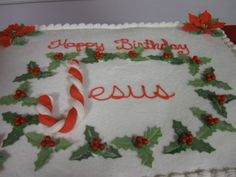 a large sheet cake decorated with holly leaves and candy canes, says happy birthday jesus