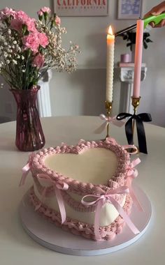 a cake sitting on top of a table next to a vase with flowers in it