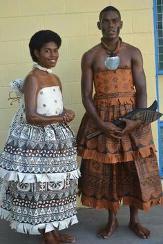 two people standing next to each other in front of a building